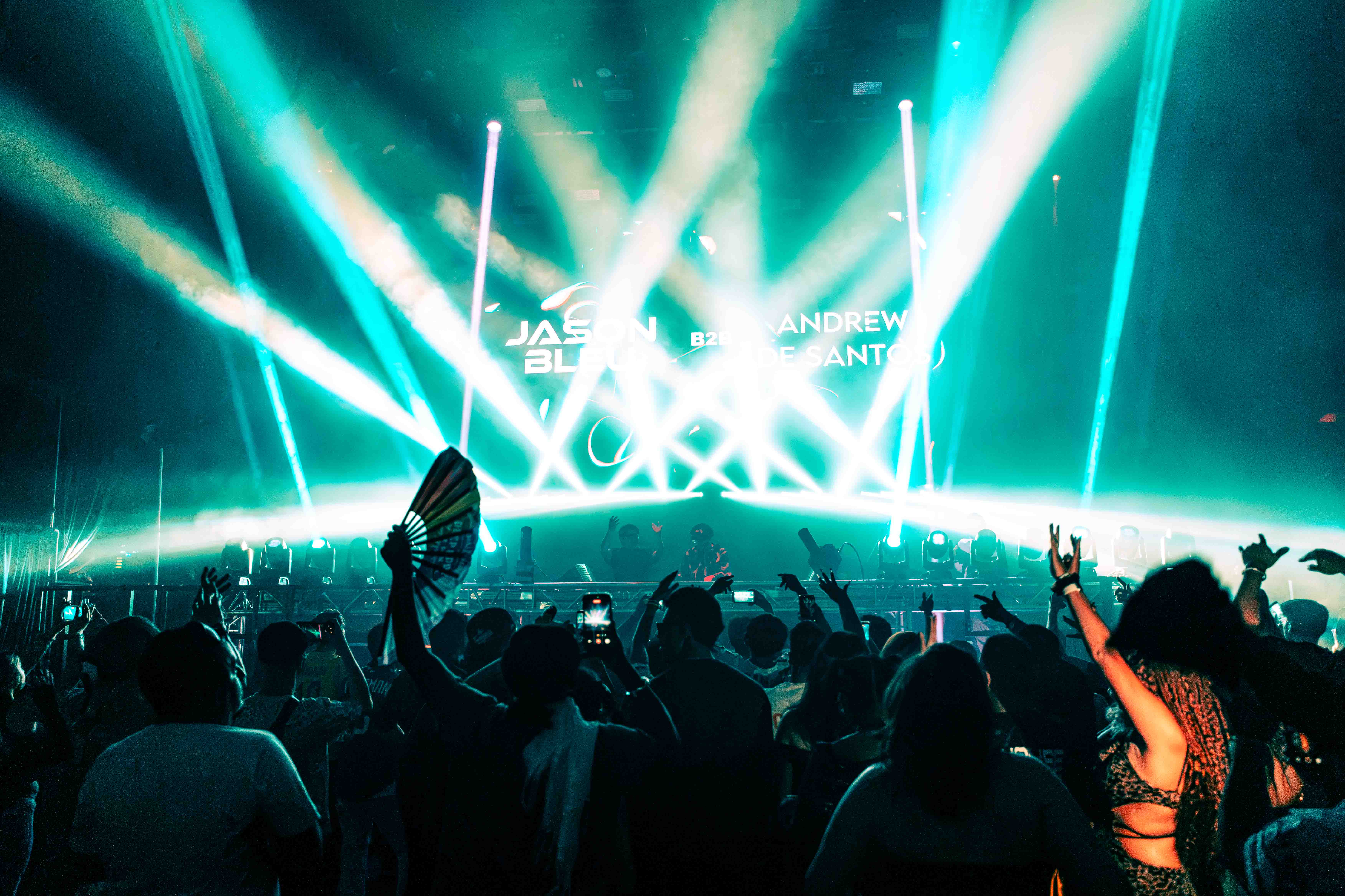 Electric guitar player with stage lights creating lens flare and dramatic shadows