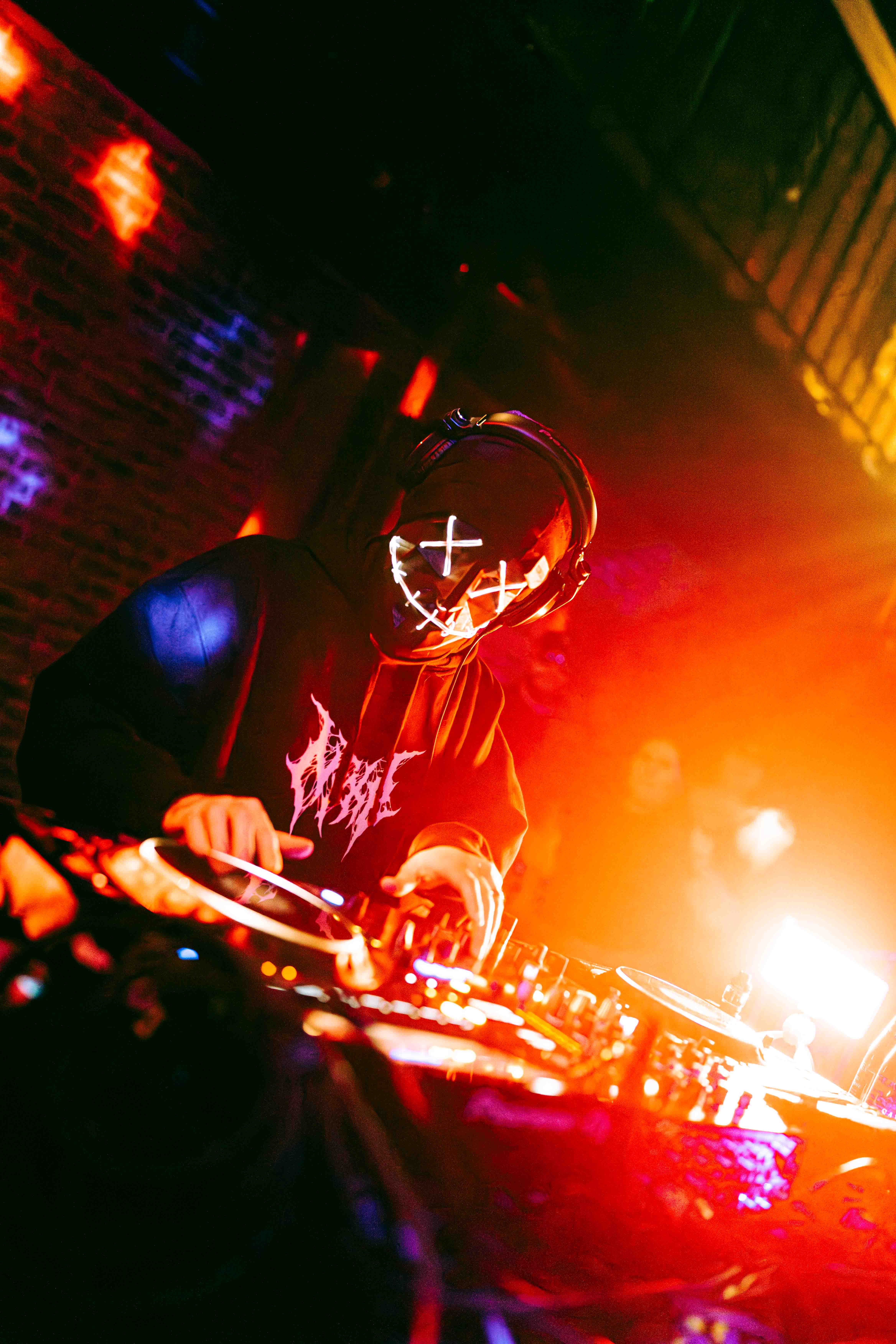 DJ performing at festival with massive LED screen backdrop and laser light show